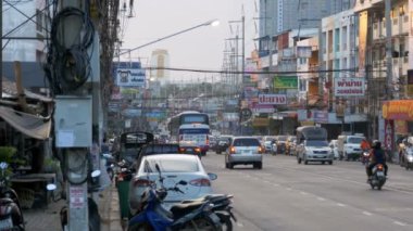 Motosikletler ve arabalar Asya yolları boyunca sürerler. Trafikle dolu Tayland caddeleri. Tayland, Pattaya