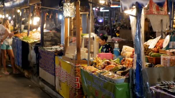 La gente camina por el Mercado de Comida Nocturna Jomtien. Contadores con comida asiática. Pattaya, Tailandia — Vídeo de stock