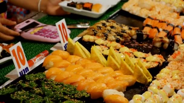 Asijské Sushi na počítadle v noci trhu s potravinami z Jomtien. Pattaya, Thajsko — Stock video