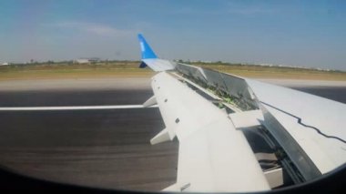 Bangkok Havaalanı pist boyunca hareketli bir uçağın kanat penceresinde göster.