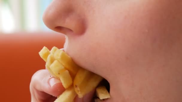 Jeune femme pousse une frite dans sa bouche dans le restaurant — Video