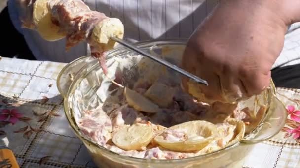 Fat Man pone la carne en escabeche en un pincho para un shish kebab — Vídeo de stock