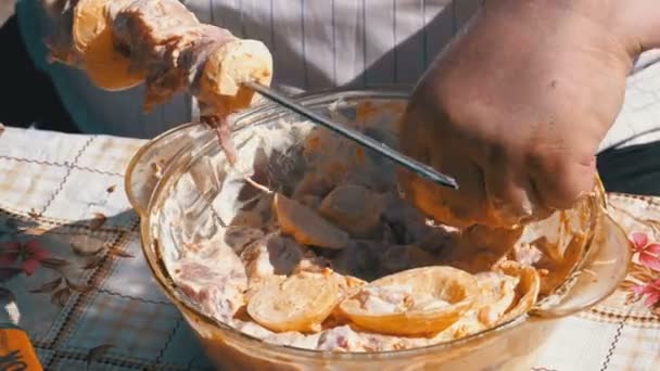 Fat Man pone la carne en escabeche en un pincho para un shish kebab — Vídeo de stock