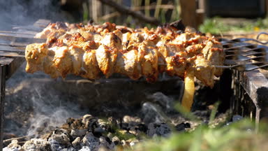 Doğada bir ateşte şiş kebap şişleri üzerinde hazırlanıyor. Ağır çekim