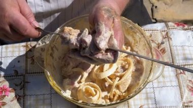 Şişman adam Marine çiğ et şiş kebap niteliğine için bir şiş koyar. Ağır çekim