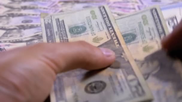 Mani Mens tenere un mucchio di dollari americani sullo sfondo del denaro rotante — Video Stock