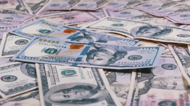 Cien billetes de dólar caen sobre la mesa con dólares americanos de diferentes denominaciones — Vídeo de stock