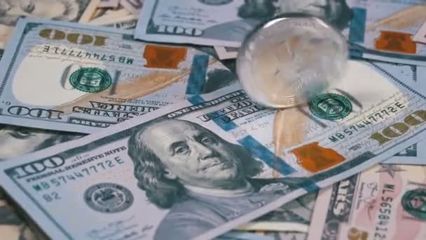 Серебряная монета Litecoin LTC вращается, скрипит, прядет и падает на стол с долларами. Slow Motion — стоковое видео