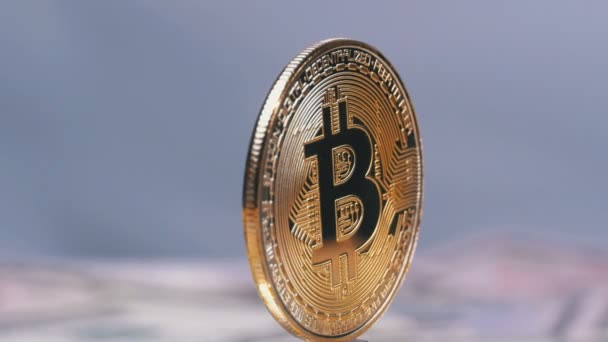 Złota moneta Bitcoin kryptowaluta, Btc obrócić na białym tle z rachunków dolarów — Wideo stockowe