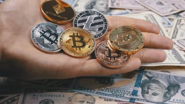 Hand houdt verschillende munten van Cryptocurrency op een tabel met Us Dollars zijn roterende — Stockvideo