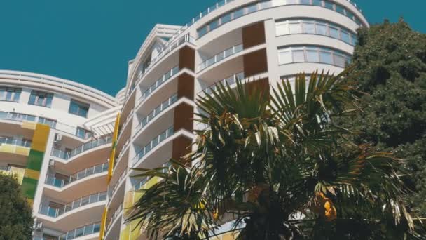 Moderno hotel a più piani e palme contro il cielo blu — Video Stock