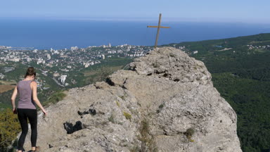 Gezgin kadın bir kayalık dağ üstüne oturuyor