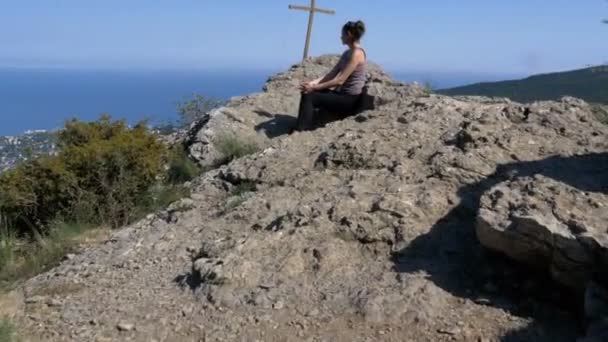 Cestující ženy sedí na vrcholu skalnaté hory — Stock video