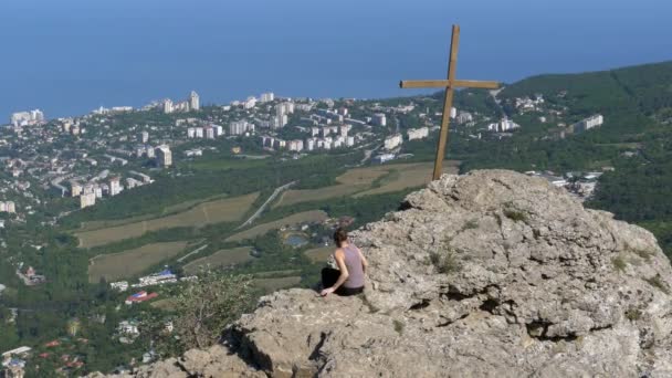 Gezgin kadın bir kayalık dağ üstüne oturuyor — Stok video