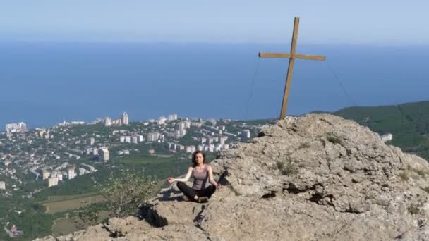 Krásná mladá žena cvičí jógu a pozice venku na neuvěřitelný útes top nastavení. — Stock video