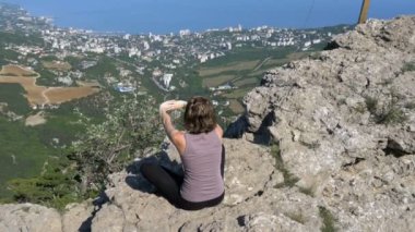 Kadın lotus pratik yoga konumda oturma taşır veya derin derin düşünür ve dağlar kadar onun kollarında yükseltir.