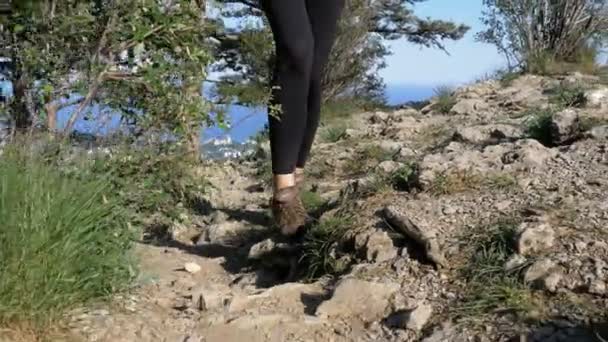 View on Feet of Traveler Woman Hiking Walking On the Top of Cliff in Mountain. Прогулка по скалам — стоковое видео
