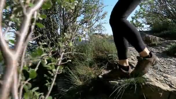 Blick auf die Füße einer Wanderin, die auf dem Gipfel der Klippe in den Bergen wandert. Zeitlupe — Stockvideo