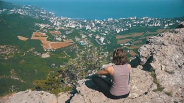 Kadın lotus pratik yoga konumda oturma taşır veya derin derin düşünür ve dağlar kadar onun kollarında yükseltir.