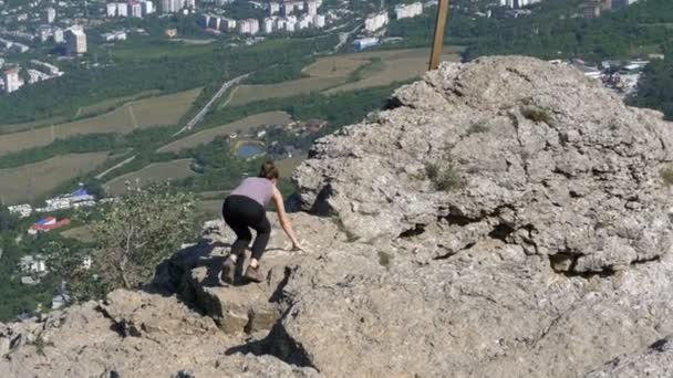 Mujer viajera se sienta en la cima de una montaña rocosa — Vídeos de Stock