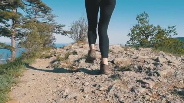 View on Feet of Traveler Woman Hiking Walking On the Top of Cliff in Mountain. Slow Motion — стоковое видео