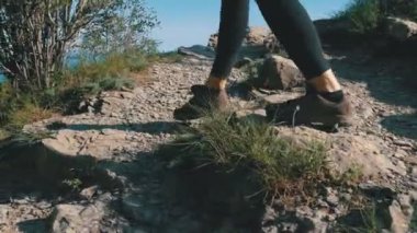 Görünüm Cliff dağ üstünde yürüme Hiking Traveler kadının ayakları üzerinde. Kayaların üzerinde yürüme