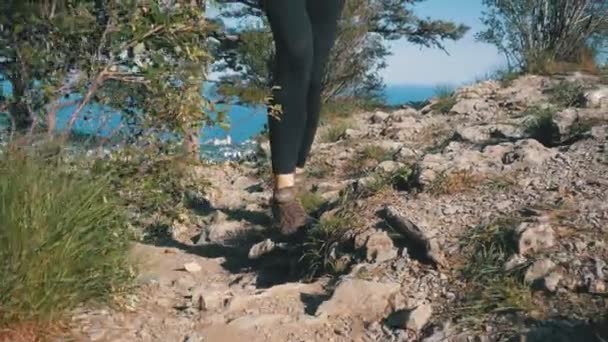 Blick auf die Füße der Wanderin, die auf der Spitze der Klippe in den Bergen wandert. Wandern auf Felsen — Stockvideo