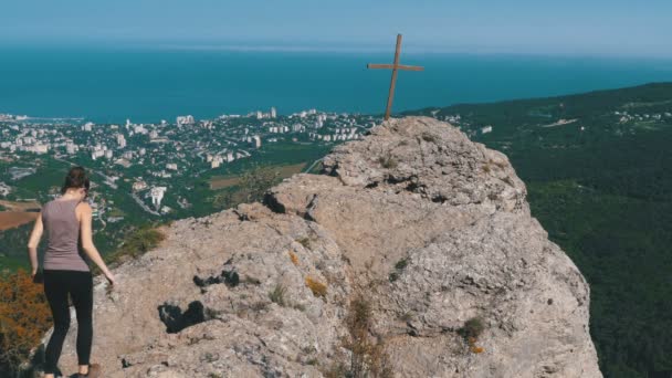 Mujer viajera se sienta en la cima de una montaña rocosa — Vídeos de Stock