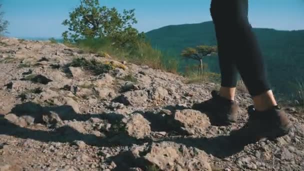 Pohled na nohou ženy turistické pěší chůzi na vrcholu útesu v Mountain. Chůze na skalách — Stock video