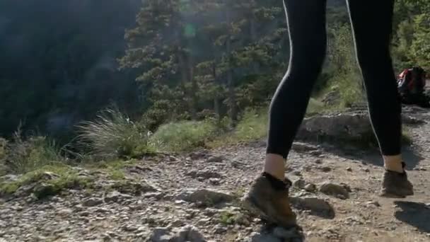 View on Feet of Traveler Woman Hiking Walking On the Top of Cliff in Mountain. Slow Motion — стоковое видео