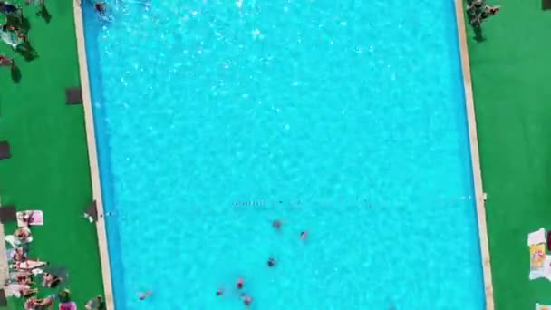 Volo sopra la piscina blu con persone in vacanza. Vista aerea sulla piscina pulita — Video Stock