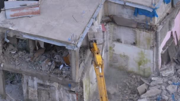 Förstöra gamla betonghus med hjälp av mekanisk arm Bulldozer på byggarbetsplatsen — Stockvideo
