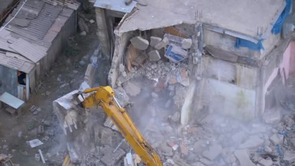 Уничтожение старого бетонного дома с помощью механического оружия бульдозера на строительной площадке — стоковое видео