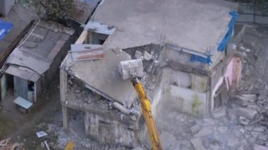İnşaat alanındaki kova kazıcıyı kullanarak Eski Ev 'i yok etmek. Zaman Uygulaması
