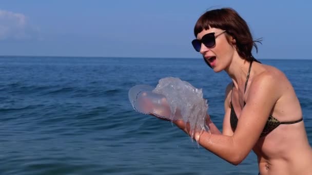 Woman Holds a Big Sea Jellyfish against the backdrop of the Black Sea (em inglês). Rizostoma — Vídeo de Stock