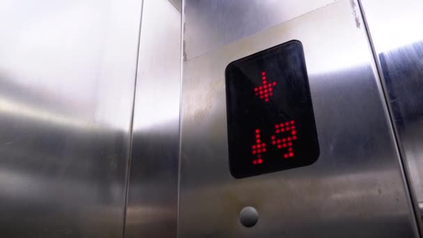 Digitale display in de lift met pijl naar beneden toont vloeren van 15e tot 7e — Stockvideo
