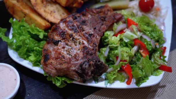 Filete en costillas con papas y ensalada en una mesa en un restaurante georgiano — Vídeos de Stock