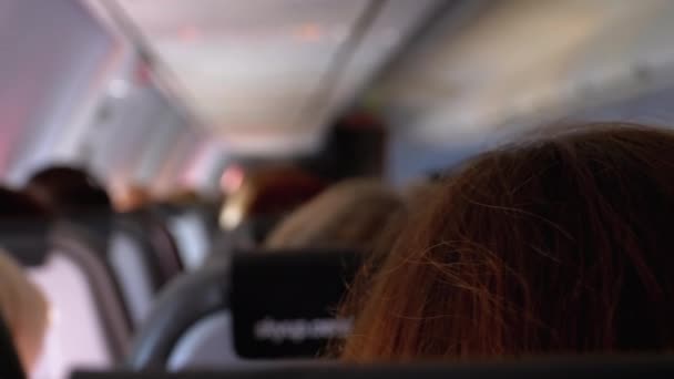 Salon samolotu pasażerskiego z osobami siedzącymi w fotelach podczas lotu. — Wideo stockowe