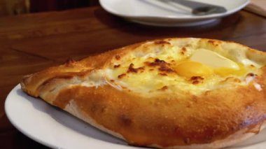 Adjarian Khachapuri Gürcistan Restoranında bir masada. Yumurta sarısı ile Ekmek Turtası Aç