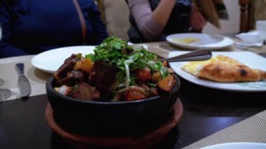 Ojahuri. Bir Gürcü restoranında Clay Pan 'da patates ve otlu kızarmış domuz eti..
