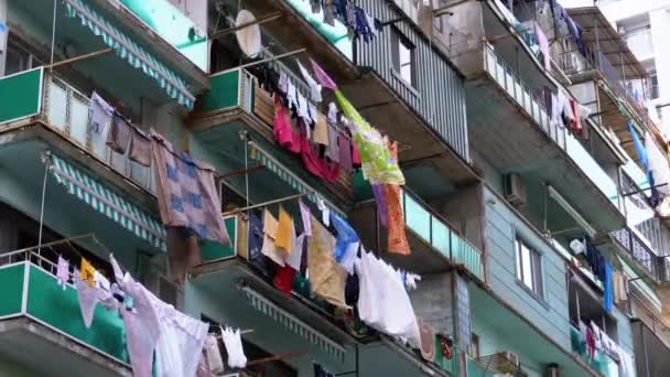 Zavěšení a sušení na laně ve vícepatrové budově v chudé čtvrti města oblečení — Stock video