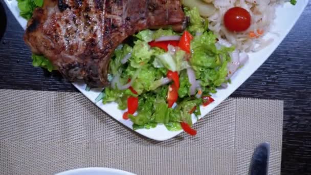 Stek na żeberkach z ziemniakami i sałatką na stole w gruzińskiej restauracji — Wideo stockowe