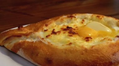 Adjarian Khachapuri Gürcistan Restoranında bir masada. Yumurta sarısı ile Ekmek Turtası Aç