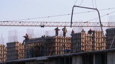 İnşaat alanındaki inşaatçılar. İnşaat alanındaki turna yükünü kaldırıyor. Yapı Yapımı.