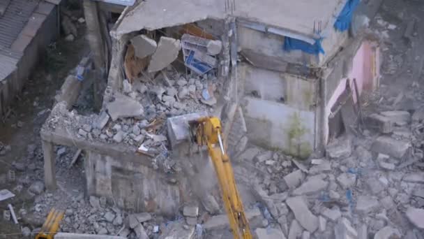 건축 현장에서 양동 이 굴착기를 사용하여 낡은 집을 파괴하는 모습. — 비디오