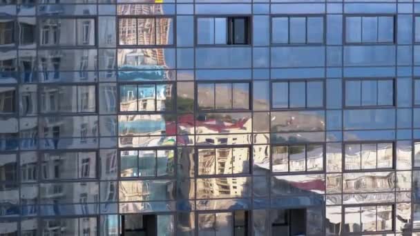 Отражение города в окнах современного здания — стоковое видео