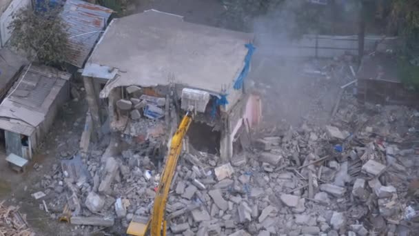 Destruyendo la vieja casa usando excavadora de cubo en el sitio de construcción . — Vídeo de stock