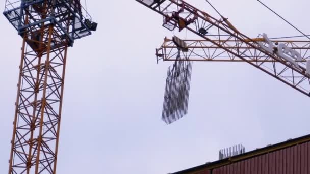 Construction de bâtiments. Une grue sur un chantier soulève une charge .