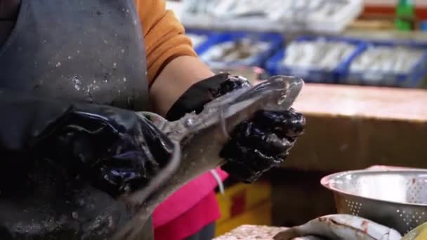 Escala y corte de pescado en el puesto del mercado. Mujer Limpieza manual y cortes de pescado fresco — Vídeo de stock