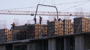 İnşaat alanındaki inşaatçılar. İnşaat alanındaki turna yükünü kaldırıyor. Yapı Yapımı.